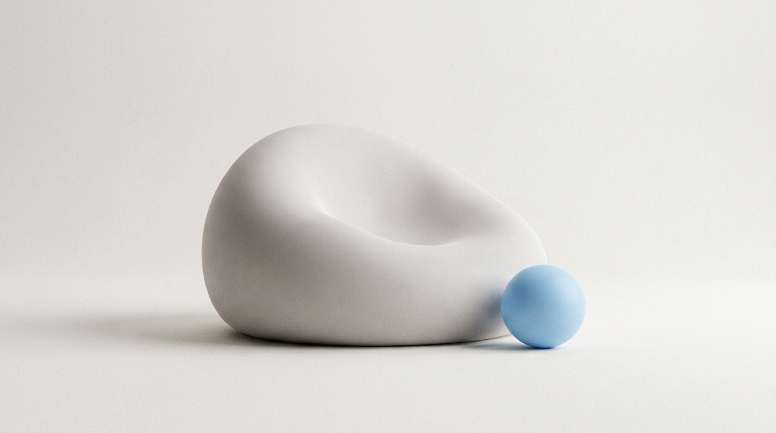 A large soft pale-grey form resting low and gently slumped on a calm off-white surface, as if it has run out of air, with one small sky-blue sphere beside it still full and holding its shape.
