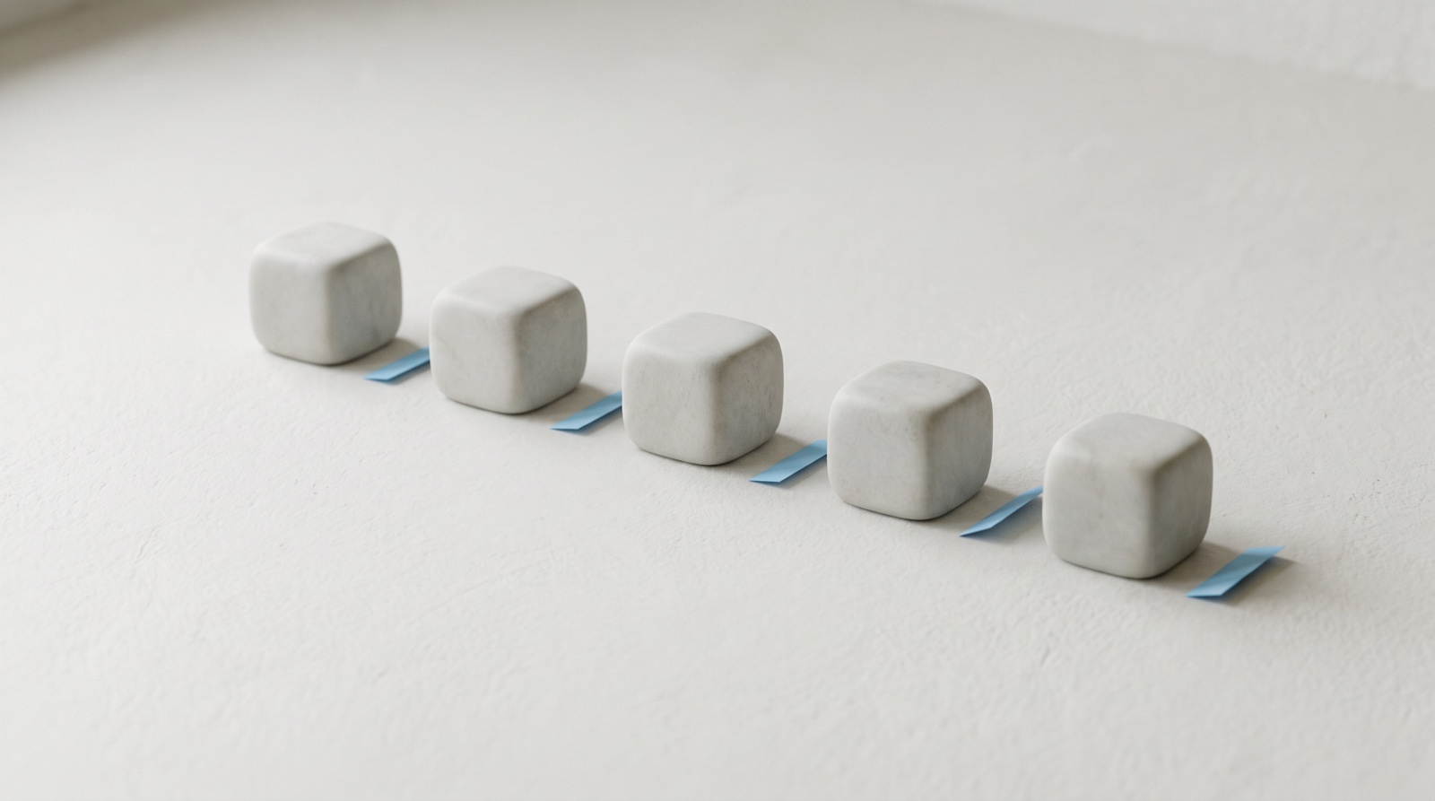 A short row of smooth pale-grey blocks on a calm off-white surface, with a thin sky-blue sliver lifted and set aside beside each one, like a small piece taken from every single thing.