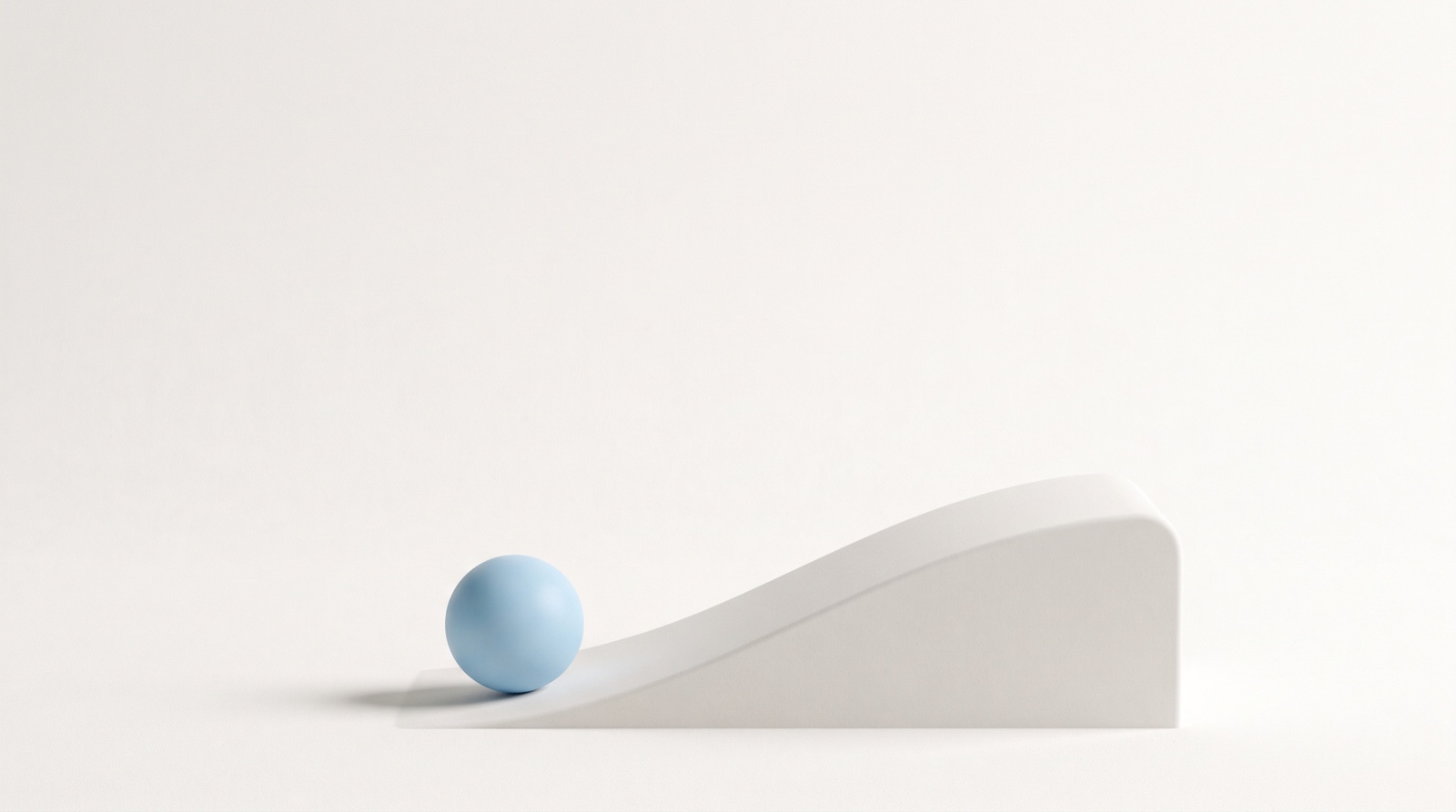 A single smooth sky-blue sphere resting at the foot of a low pale-grey ramp on a calm off-white surface, suggesting the moment just before something begins to move.